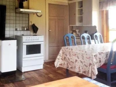 a kitchen with a table and a kitchen with blue chairs at 11 person holiday home in Bud-By Traum in Bud
