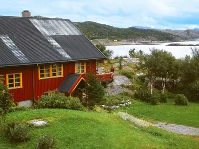 a red house with solar panels on top of it at 15 person holiday home in Flatanger-By Traum in Straum