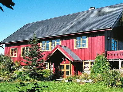 a red barn with a black roof at 15 person holiday home in Flatanger-By Traum in Straum