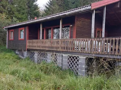 a wooden cabin with a porch on a hill at 7 person holiday home in Skjold-By Traum in Skjold