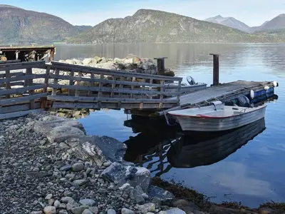 a boat is docked at a dock on a lake at 2 person holiday home in Måndalen-By Traum in Sæbø