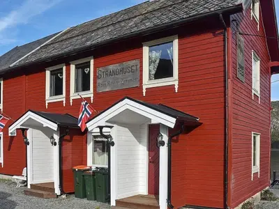 a red building with a sign on the side of it at 4 person holiday home in Måndalen-By Traum in Sæbø