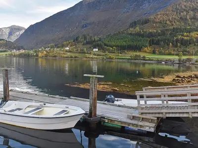 a boat is docked at a dock on a lake at 4 person holiday home in Måndalen-By Traum in Sæbø