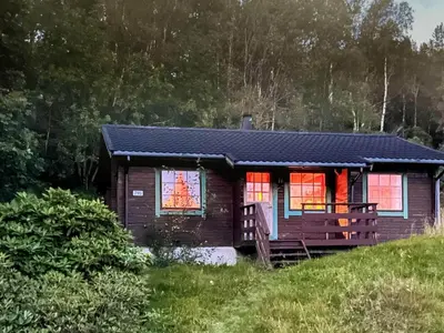 a small house on a hill with red windows at 5 person holiday home in Brekke-By Traum in Dingja