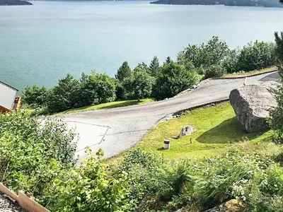 an empty road next to a body of water at 8 person holiday home in Norheimsund-By Traum in Norheimsund