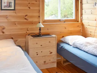 a bedroom with two beds and a dresser and a window at 7 person holiday home in Selje-By Traum in Selje
