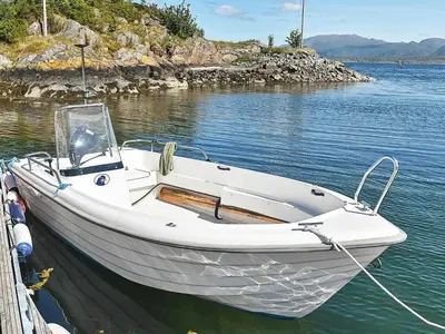 a white boat tied to a dock in the water at 6 person holiday home in Farstad-By Traum in Farstad