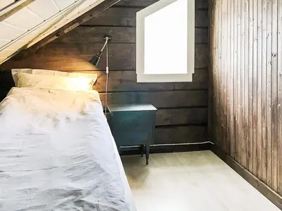 a bed in a room with a wooden wall at 11 person holiday home in Fjørtoft-By Traum in Fjørtoft