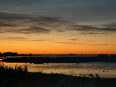 a sunset over a body of water with birds in the water at 9 person holiday home in Farstad-By Traum in Farstad