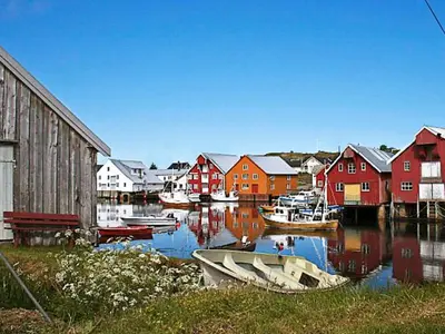 a group of boats docked in a harbor with houses at 9 person holiday home in Farstad-By Traum in Farstad