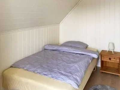 a bedroom with a bed with a purple blanket at 6 person holiday home in Svelgen-By Traum in Sørgulen