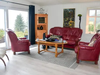 a living room with red leather chairs and a coffee table at 6 person holiday home in Åram-By Traum in Sandvik