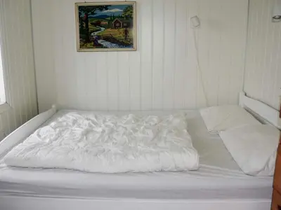 a white bed in a room with a picture on the wall at 6 person holiday home in Åram-By Traum in Sandvik
