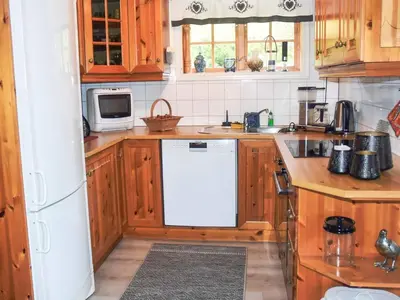 a kitchen with wooden cabinets and a white dishwasher at 6 person holiday home in Åram-By Traum in Sandvik
