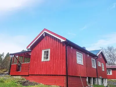 a red house with white windows in a field at 6 person holiday home in Storfosna-By Traum in Sletta