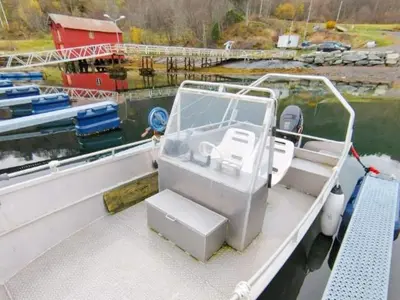 a white boat tied to a dock in the water at 4 person holiday home in Øydegard-By Traum in Torvikbukt