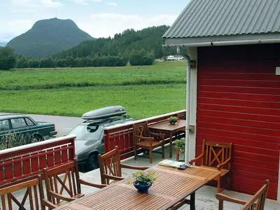 a patio with a table and chairs and a car at 8 person holiday home in isfjorden-By Traum in Torvik