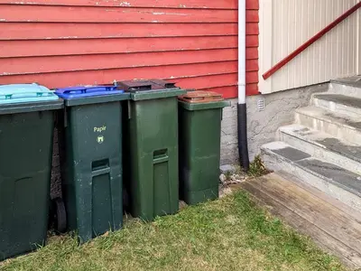 three green trash cans sitting next to a house at 8 person holiday home in isfjorden-By Traum in Torvik