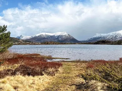 a body of water with snow covered mountains in the background at 9 person holiday home in GURSKØY-By Traum in Kjellsund