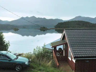 a car parked outside of a house with a view of a lake at 4 person holiday home in VÅGLAND-By Traum in Rabben
