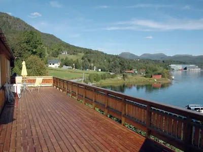 a wooden deck with a view of a lake at 4 person holiday home in VÅGLAND-By Traum in Rabben