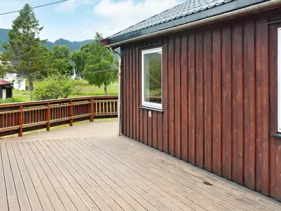 a house with a wooden deck with a window at 4 person holiday home in VÅGLAND-By Traum in Rabben