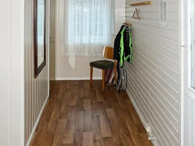 a hallway with wood flooring and a chair and a window at 4 person holiday home in Lauvstad-By Traum in Lauvstad