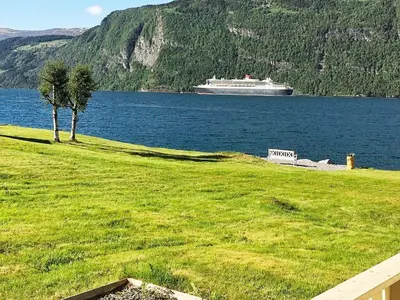 a cruise ship on the water with a tree at 4 person holiday home in Utvik-By Traum in Reed