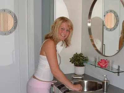 a woman standing in front of a sink in a bathroom at 6 person holiday home in Kalvåg-By Traum in Kalvåg