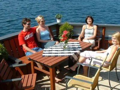 a group of people sitting around a table on a boat at 6 person holiday home in Kalvåg-By Traum in Kalvåg
