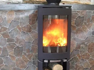 a wood stove in a stone wall at 8 person holiday home in Kalvåg-By Traum in Kalvåg
