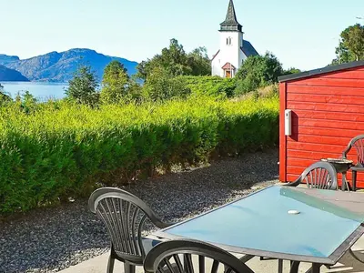 a ping pong table and a bench next to a church at 6 person holiday home in Sørbøvåg-By Traum in Sørbø