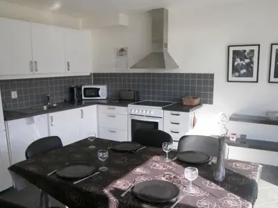 a kitchen with a table and chairs and a kitchen with white cabinets at 6 person holiday home in Sørbøvåg-By Traum in Sørbø