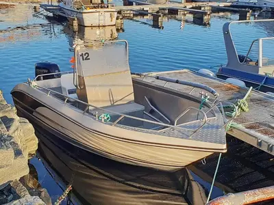 a boat tied up to a dock in the water at 6 person holiday home in Oksvoll-By Traum in Oksvoll
