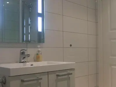 a white bathroom with a sink and a mirror at 6 person holiday home in Gursken-By Traum in Larsnes