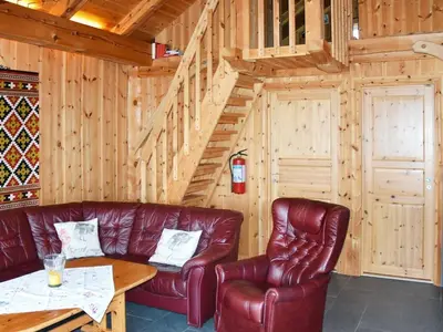 a living room with leather furniture and a wooden wall at 7 person holiday home in Blaksæter-By Traum in Sølberg