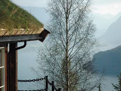 a tree next to a building with a view of a lake at 7 person holiday home in Blaksæter-By Traum in Sølberg
