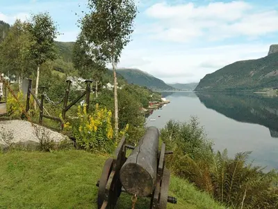 a bench sitting on the side of a lake at 11 person holiday home in Syvde in Myklebost