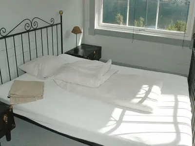 a white bed with white sheets and a window at 11 person holiday home in Syvde in Myklebost