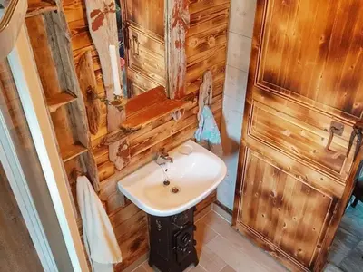 a bathroom with a sink and a wooden wall at 11 person holiday home in Syvde in Myklebost