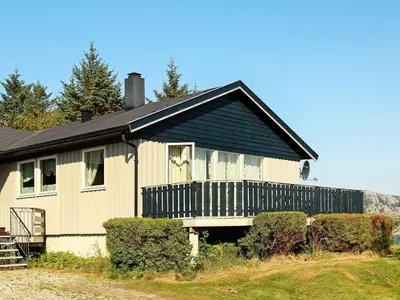 a house with a black roof and a porch at 12 person holiday home in Kvenvær in Kvenvær