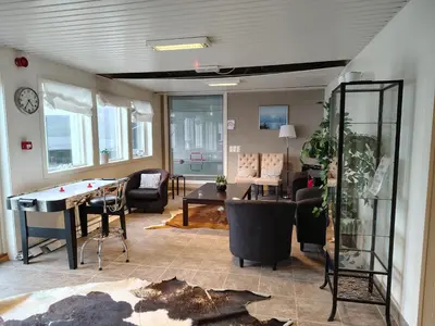 a living room with a ping pong table and chairs at Oppheim Holiday Apartment in Øyjordi