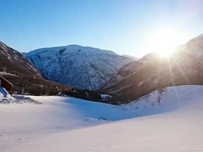 a snow covered mountain with the sun shining on it at 6 person holiday home in Øvre Årdal in Øvre Årdal