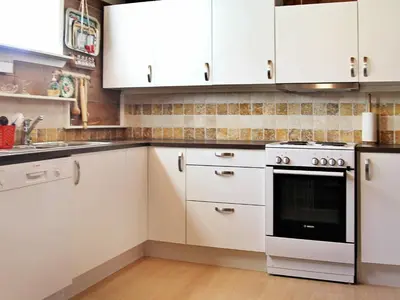a kitchen with white cabinets and an oven at 10 person holiday home in Bygstad in Bygstad