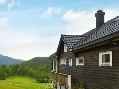 a wooden house with a view of the mountains at 10 person holiday home in Bygstad in Bygstad