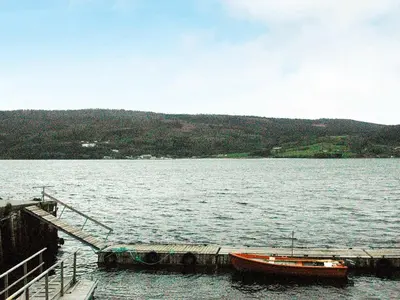 a boat is docked at a dock on a lake at 4 person holiday home in Surna in Glerem