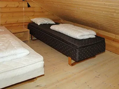 two beds sitting next to each other in a room at 5 person holiday home in VÅGLAND in Bårdset