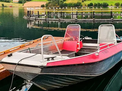 a small boat tied to a dock in the water at 5 person holiday home in VÅGLAND in Bårdset