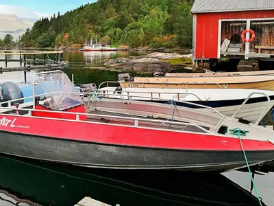 a red boat is docked at a dock at 5 person holiday home in VÅGLAND in Bårdset