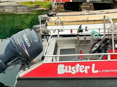 a red and white boat sitting in the water at 5 person holiday home in VÅGLAND in Bårdset